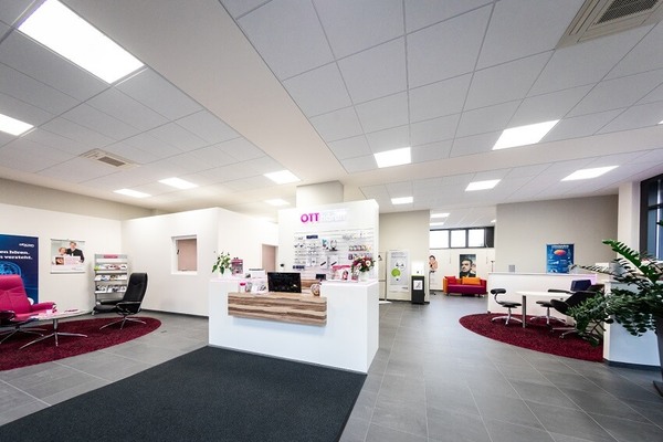 Modernes Hörakustik-Fachgeschäft mit Empfangstresen, Beratungsecken und Wartebereich.